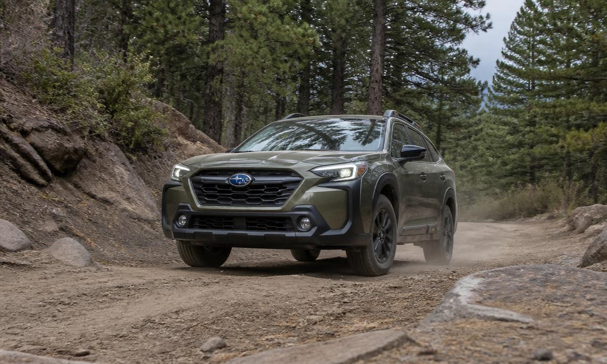 Subaru Outback driving up a rutted dirt trail in the mountains