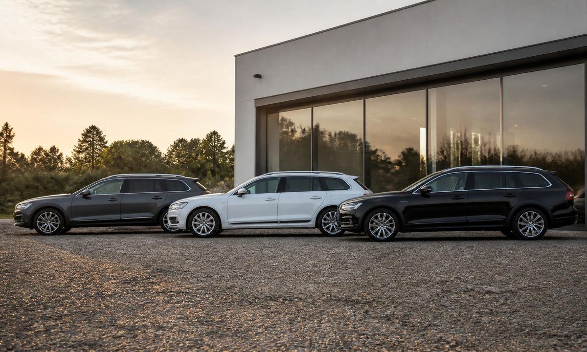 Three Subaru wagons in a row parked on gravel at golden hour outside a modern building